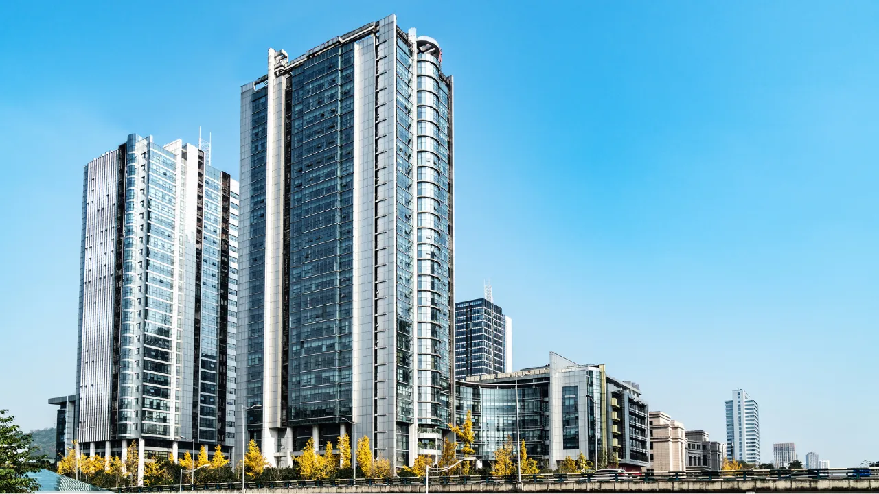 Modern luxury high-rise apartments in Ahmedabad featuring sleek glass architecture, premium design, and city skyline views, representing upscale living in prime residential areas like Bodakdev and SG Highway.