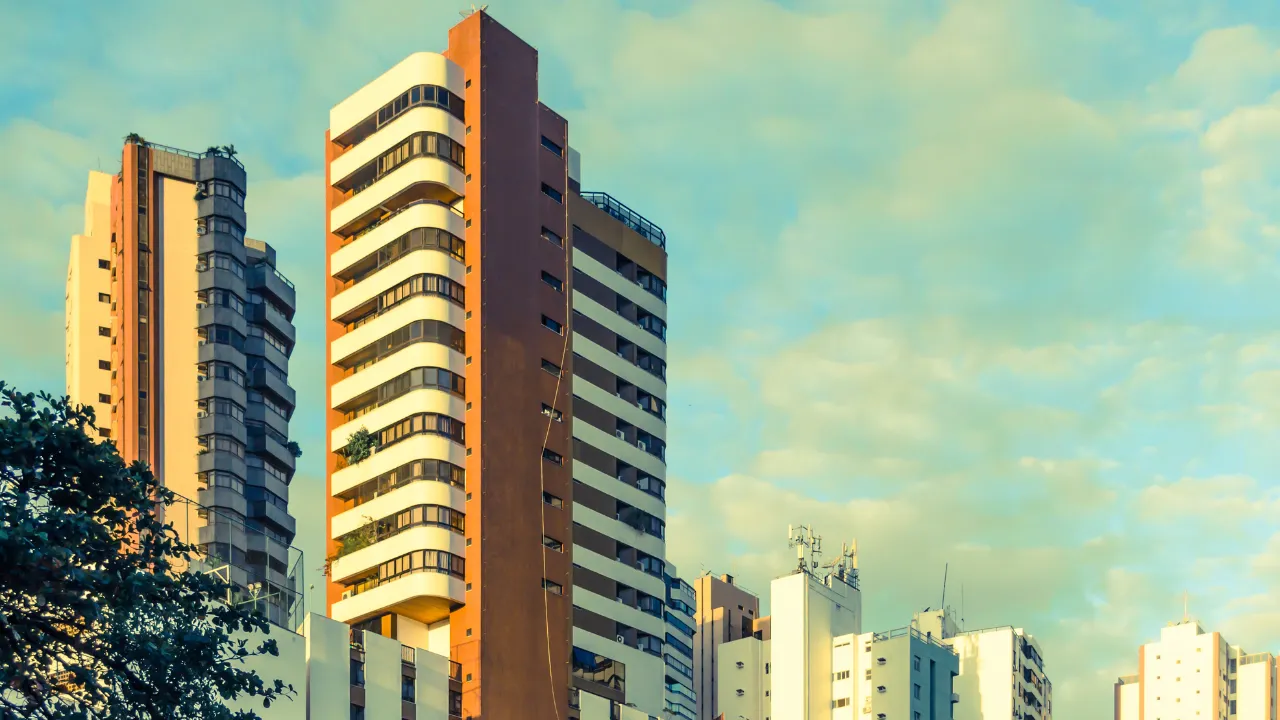 High-rise affordable apartment buildings in Ahmedabad under a warm sky, representing budget-friendly housing options with essential amenities for families and first-time homebuyers.