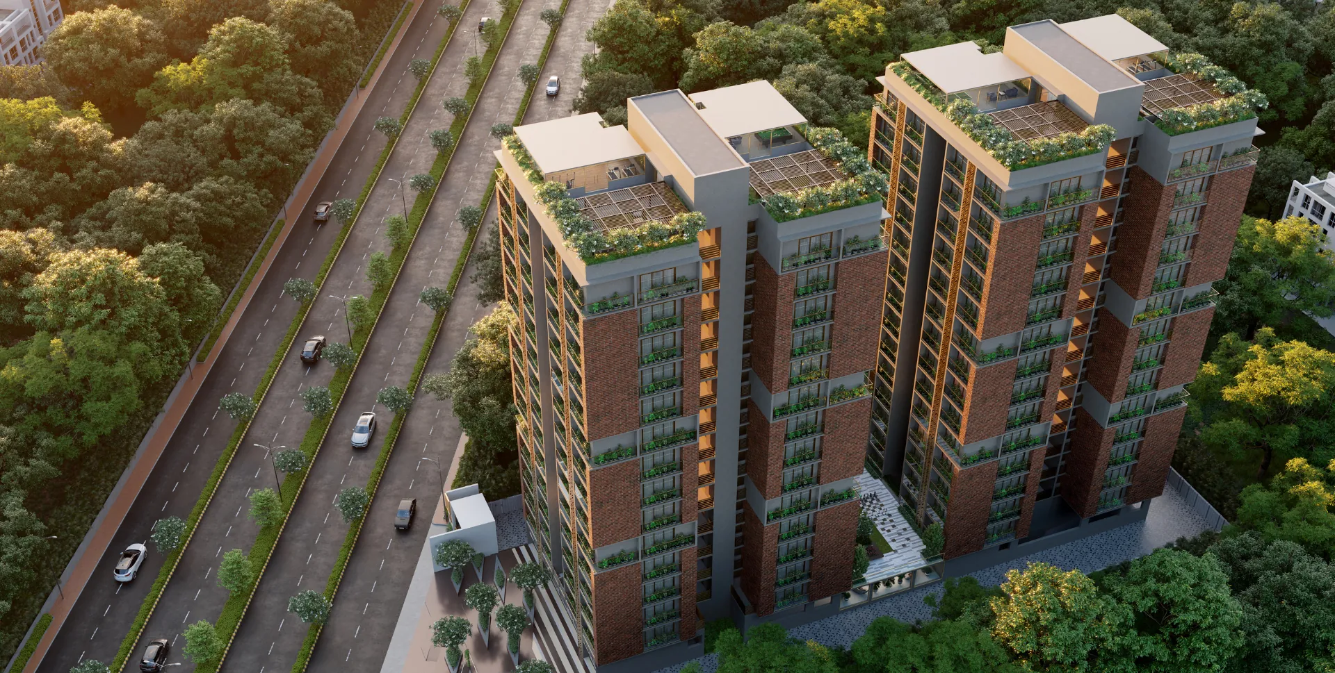 Aerial view of Laxmi One O1, Bhadaj - two brick-and-gold apartment towers near Science City, Ahmedabad, with planted balconies, rooftop sky gardens and a landscaped courtyard between them.