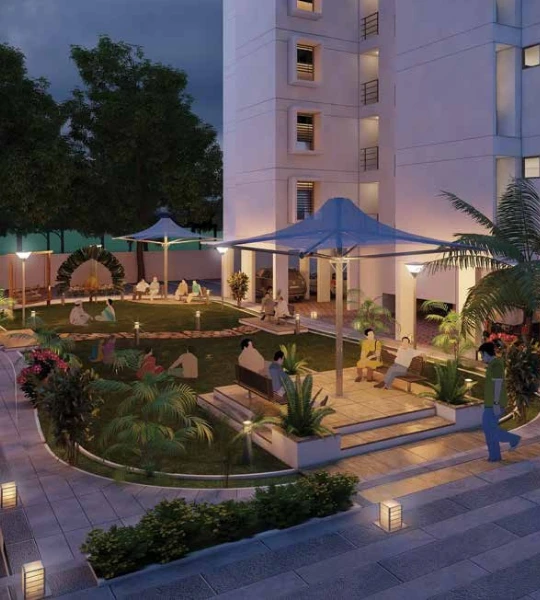 Evening view of the lush green garden area at Laxmi SkyCity, Naroda, Ahmedabad, with residents relaxing in the serene surroundings. The well-lit landscape provides a perfect spot for evening strolls and socializing.