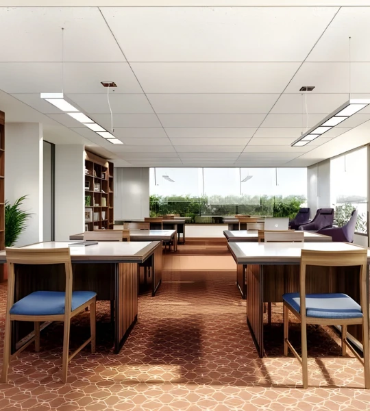 A modern, well-lit co-working space at a Laxmi Group project in Ahmedabad, offering ample seating, a professional environment, and large windows with a view of greenery. Ideal for work-from-home setups and a comfortable living experience.