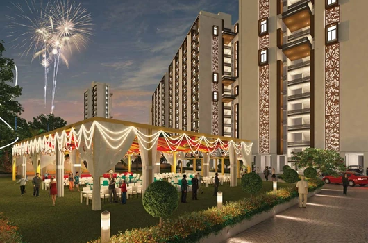 An architectural rendering of a Laxmi Group residential project in Ahmedabad featuring modern 3 BHK Flat in Ahmedabad and a decorated outdoor community event space with a festive marquee and fireworks in the night sky.