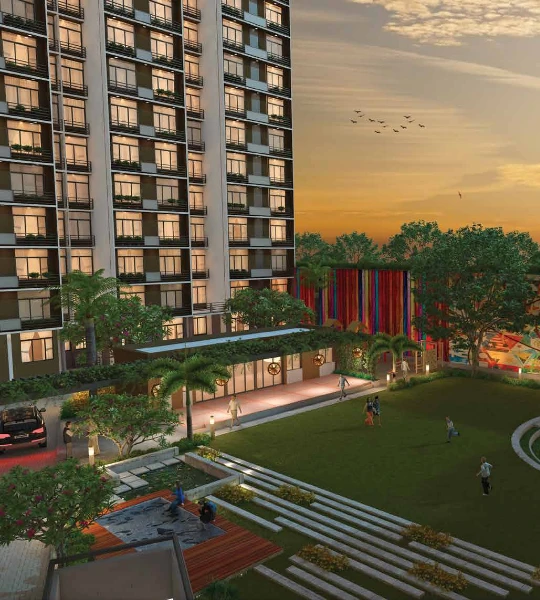 Evening view of one of a Laxmi Group new residential projects in Ahmedabad, featuring a modern building, landscaped gardens, and recreational spaces like a playground and seating areas. Ideal for families, with luxury amenities and a convenient location near schools, hospitals, and shopping centers.