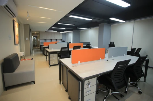 "Interior view of a modern office space in a commercial project by Laxmi Group in Ahmedabad, featuring desks, chairs, and a clean, professional design."